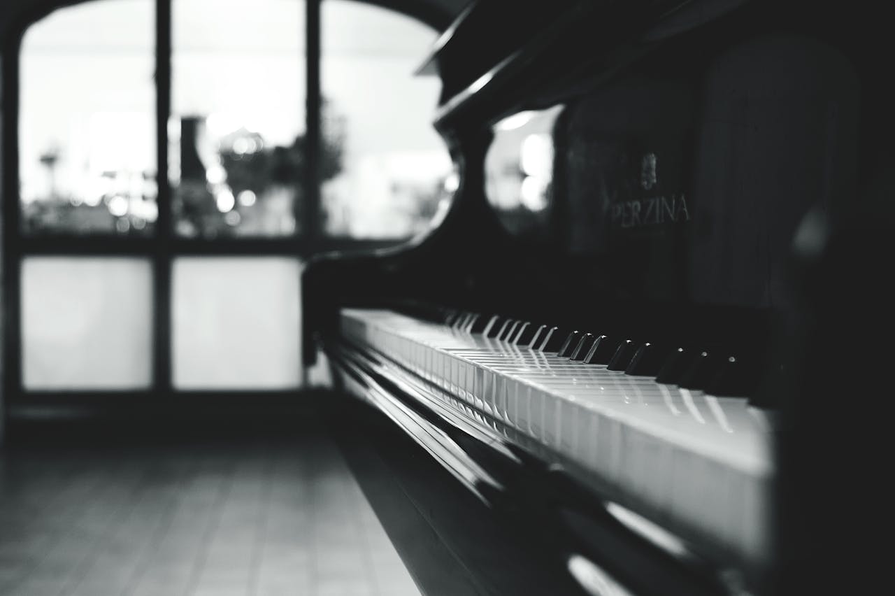 Stylish black and white close-up of a piano inside a room with soft lighting.