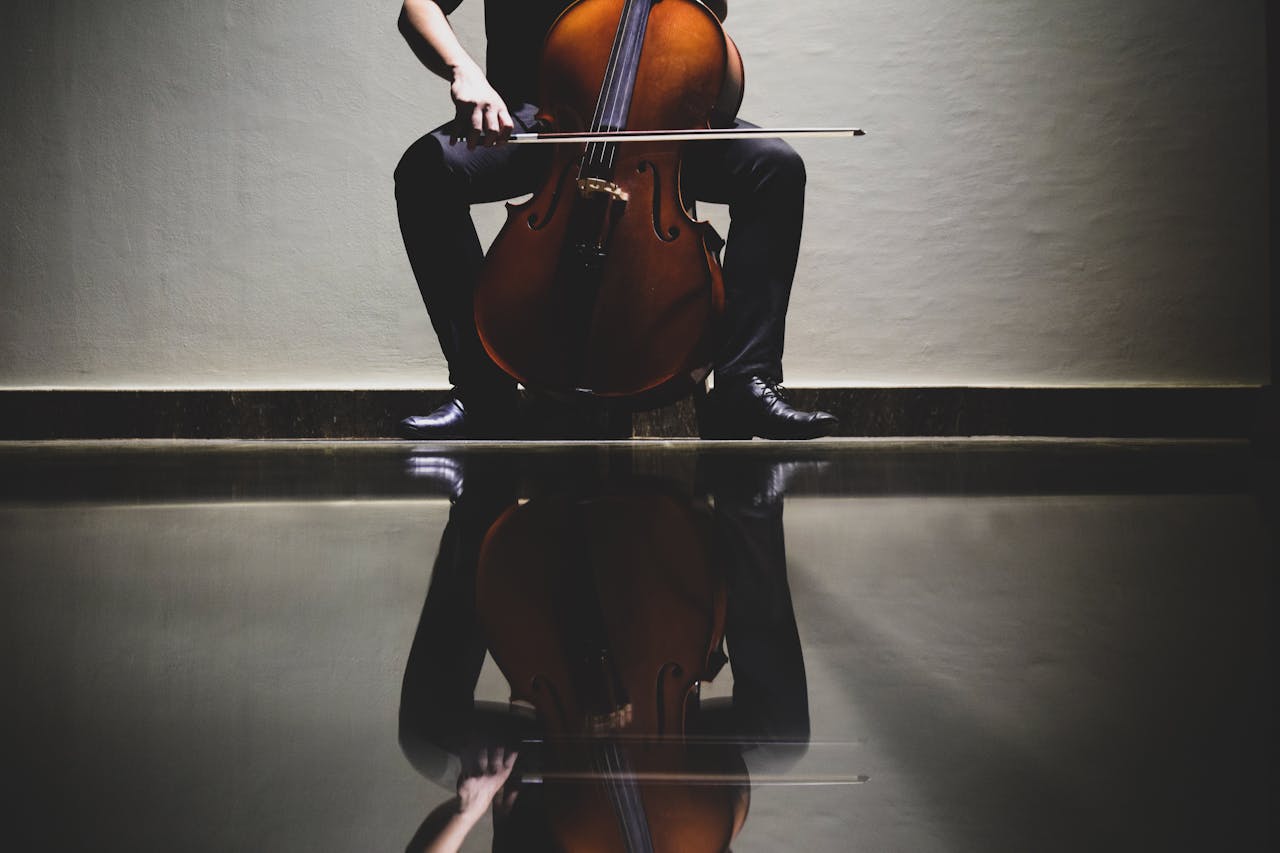 Elegant reflection of a cellist playing a cello in an indoor setting, emphasizing classical music themes.